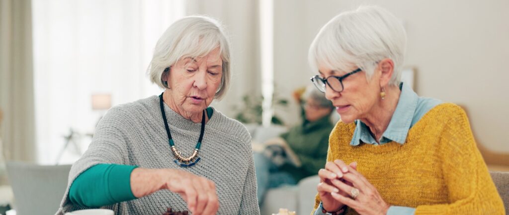 Senior women playing chess together at the table
